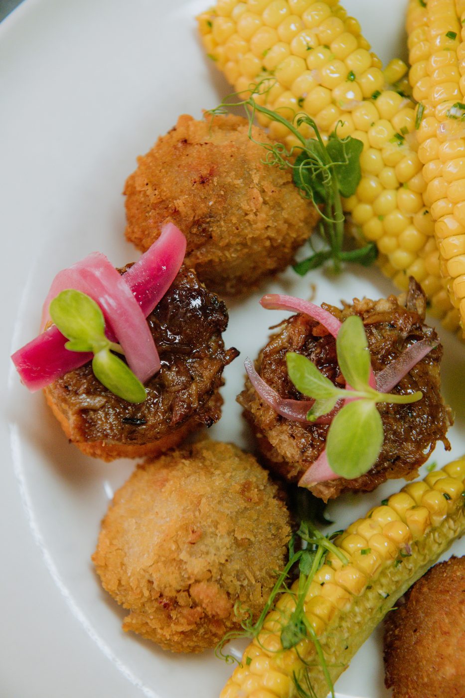 Chilli con carne kroketi i rebarca od kukuruza na tanjiru