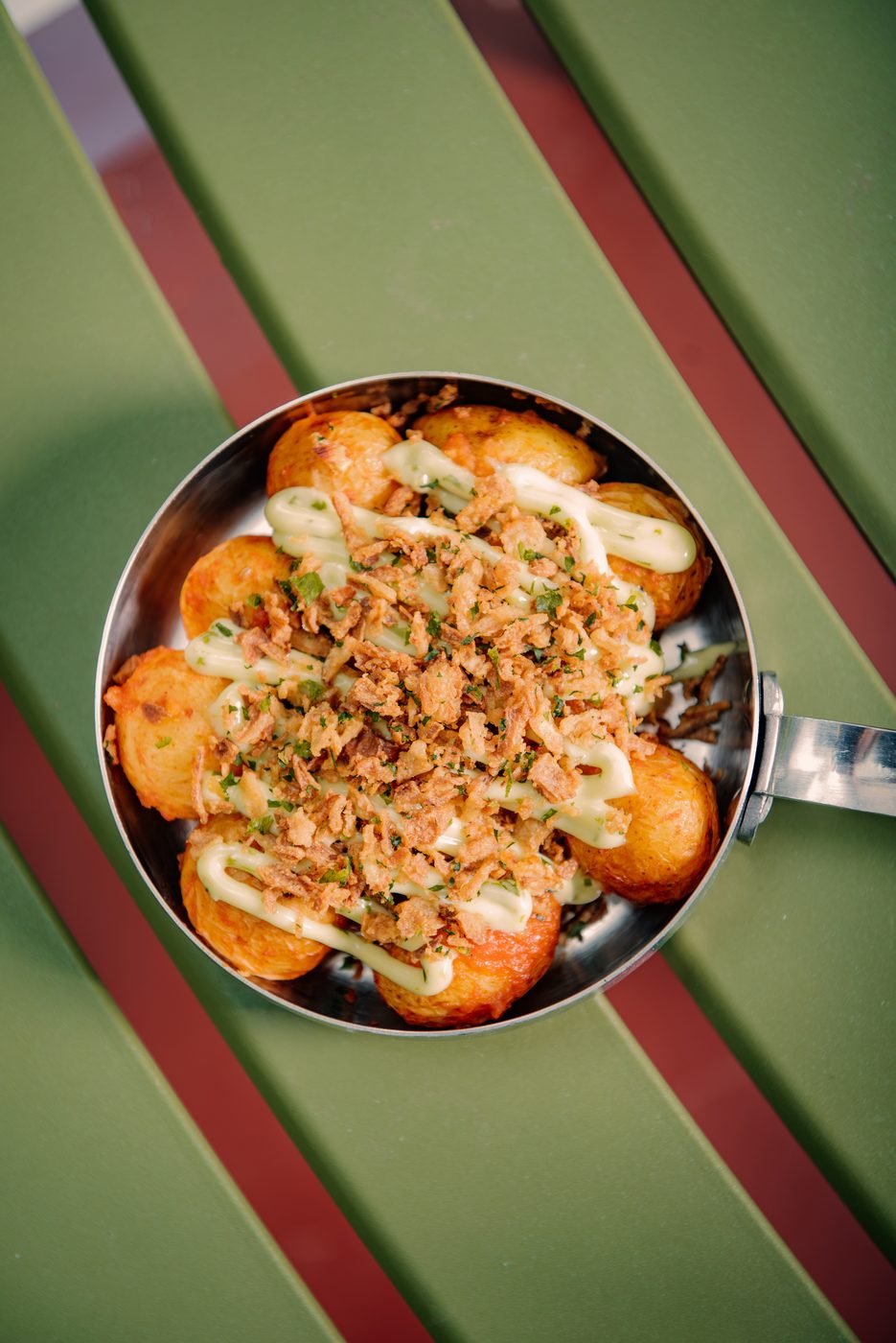 Patatas bravas sa hrskavim lukom i ajolijem u tiganju, odozgo